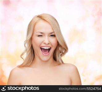 health and beauty concept - beautiful woman with long wavy hair winking