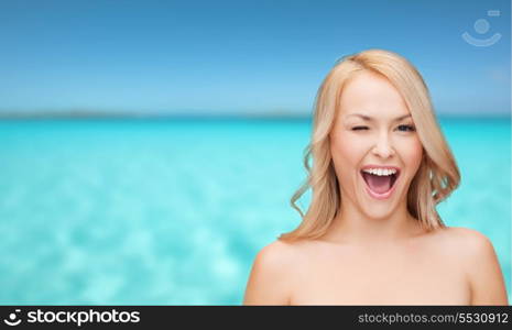 health and beauty concept - beautiful woman with long wavy hair winking