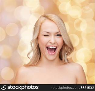 health and beauty concept - beautiful woman with long wavy hair winking