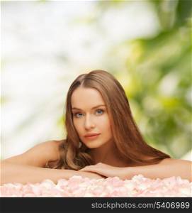 health and beauty concept - beautiful woman with rose petals and long hair