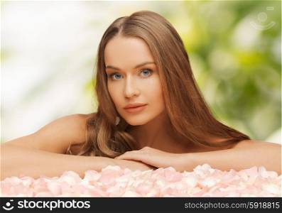health and beauty concept - beautiful woman with rose petals and long hair. woman with rose petals and long hair