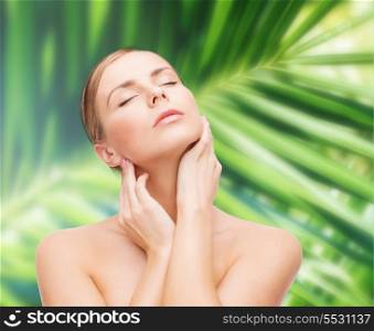 health and beauty concept - beautiful young woman touching her face with closed eyes