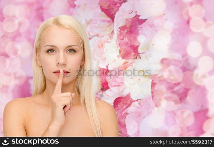 health and beauty concept - calm young woman with finger on lips