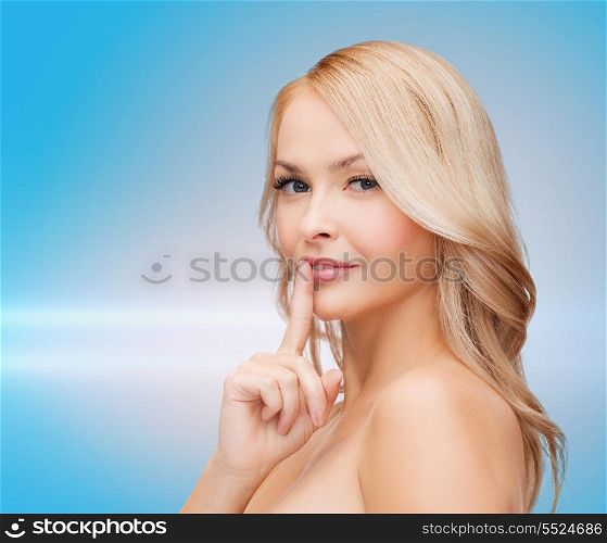 health and beauty concept - clean face of beautiful young woman pointing finger to her lips