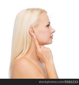 health and beauty concept - close up of clean face of beautiful young woman pointing finger to ear