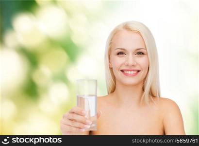 health and beauty concept - closeup of young smiling woman with glass of water