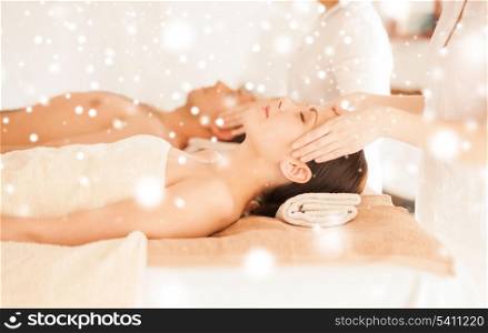 health and beauty concept - couple in spa salon getting face treatment