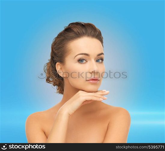 health and beauty concept - face and hands of beautiful woman with updo over blue (can be used as a template for jewelry)