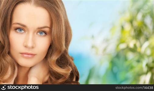 health and beauty concept - face and hands of beautiful woman with long hair