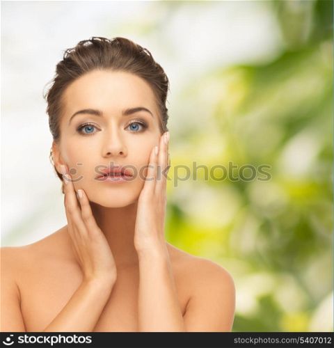 health and beauty concept - face and hands of beautiful woman with updo