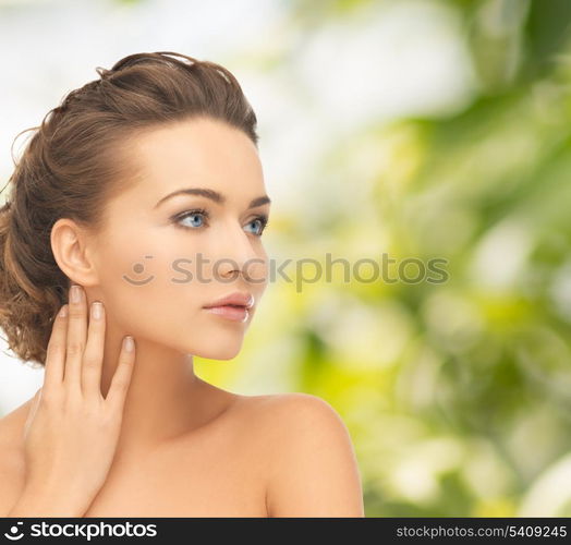 health and beauty concept - face and hands of beautiful woman with updo