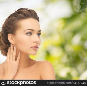 health and beauty concept - face and hands of beautiful woman with updo