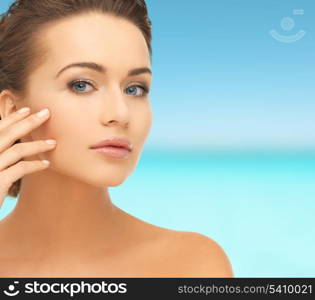 health and beauty concept - face and hands of beautiful woman with updo