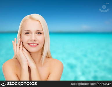 health and beauty concept - face and hands of happy woman