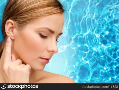 health and beauty concept - face of beautiful woman touching her ear