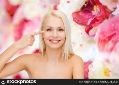 health and beauty concept - face of beautiful woman touching her eye area