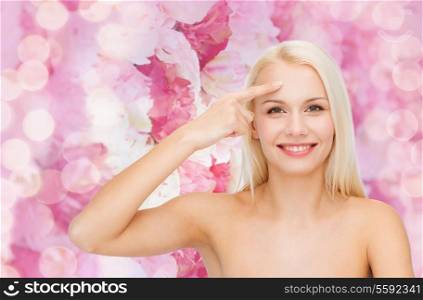 health and beauty concept - face of beautiful woman touching her forehead