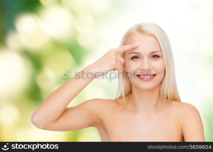 health and beauty concept - face of beautiful woman touching her forehead