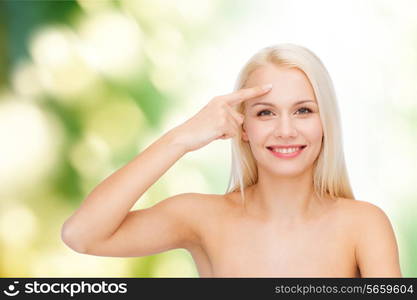 health and beauty concept - face of beautiful woman touching her forehead