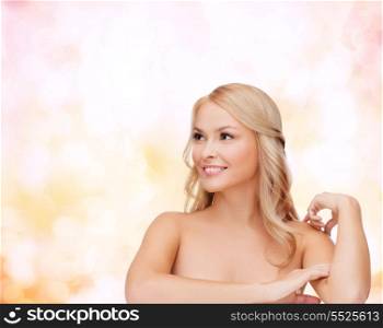 health and beauty concept - face of beautiful woman touching her shoulder skin