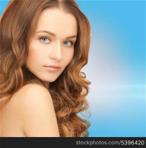 health and beauty concept - face of beautiful woman with long hair over blue background