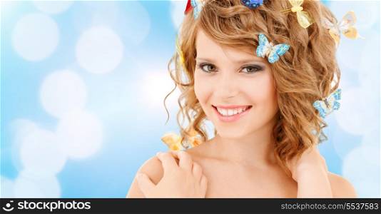 health and beauty concept - happy teenage girl with butterflies in hair
