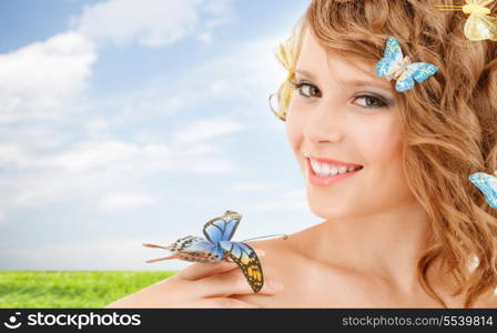 health and beauty concept - happy teenage girl with butterflies in hair and one sitting on her hand