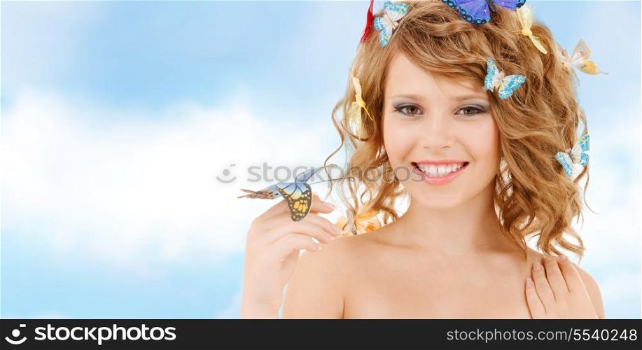 health and beauty concept - happy teenage girl with butterflies in hair and one sitting on her hand