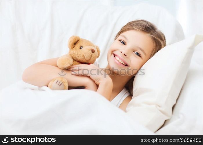 health and beauty concept - little girl with teddy bear sleeping at home