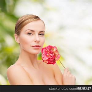 health and beauty concept - lovely woman with pink peony flower