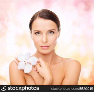 health and beauty concept - relaxed woman with orhid flower