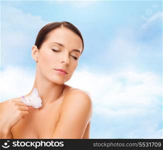 health and beauty concept - relaxed woman with orhid flower and closed eyes