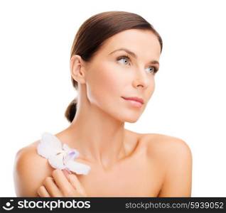 health and beauty concept - relaxed woman with orhid flower. relaxed woman with orhid flower