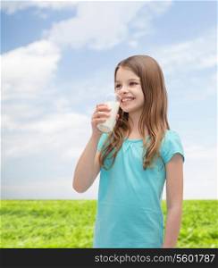 health and beauty concept - smiling little girl drinking milk out of glass