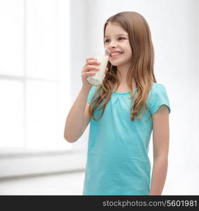 health and beauty concept - smiling little girl drinking milk out of glass