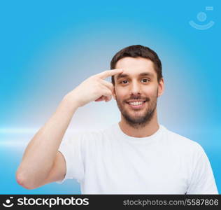 health and beauty concept - smiling young handsome man pointing to forehead