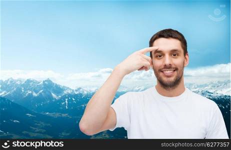 health and beauty concept - smiling young handsome man pointing to forehead
