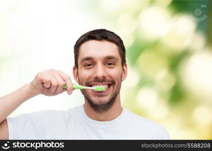 health and beauty concept - smiling young man with toothbrush