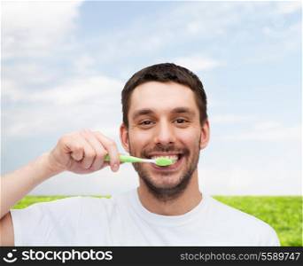 health and beauty concept - smiling young man with toothbrush