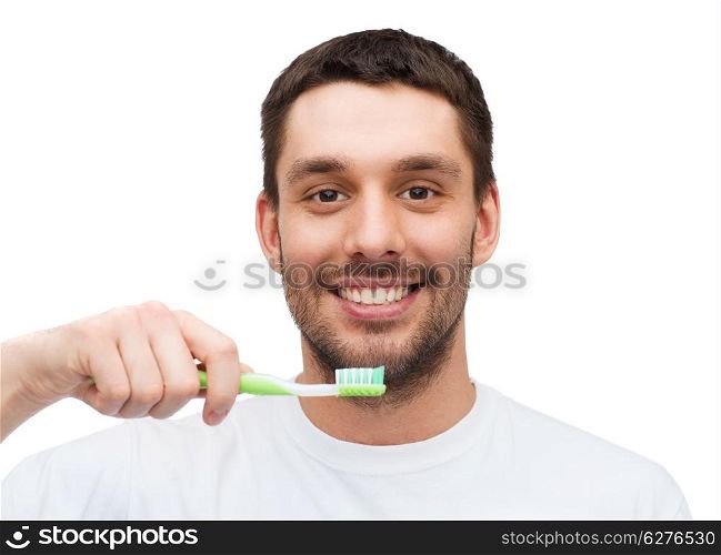 health and beauty concept - smiling young man with toothbrush