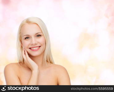 health and beauty concept - smiling young woman touching her face skin