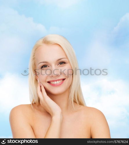 health and beauty concept - smiling young woman touching her face skin