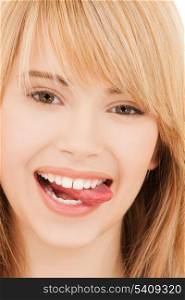 health and beauty concept - teenage girl sticking out her tongue or licking lips