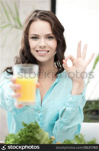health and beauty concept - woman holding glass of orange juice and showing ok sign