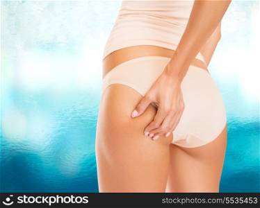 health and beauty concept - woman in cotton underwear showing skin on buttocks