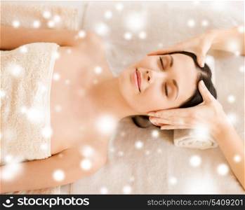 health and beauty concept - woman in spa salon getting face treatment