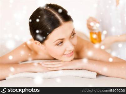 health and beauty concept - woman in spa salon getting oil treatment
