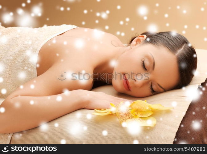 health and beauty concept - woman in spa salon lying on the massage desk