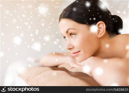 health and beauty concept - woman in spa salon lying on the massage desk