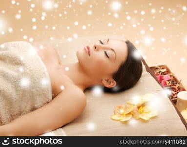 health and beauty concept - woman in spa salon lying on the massage desk